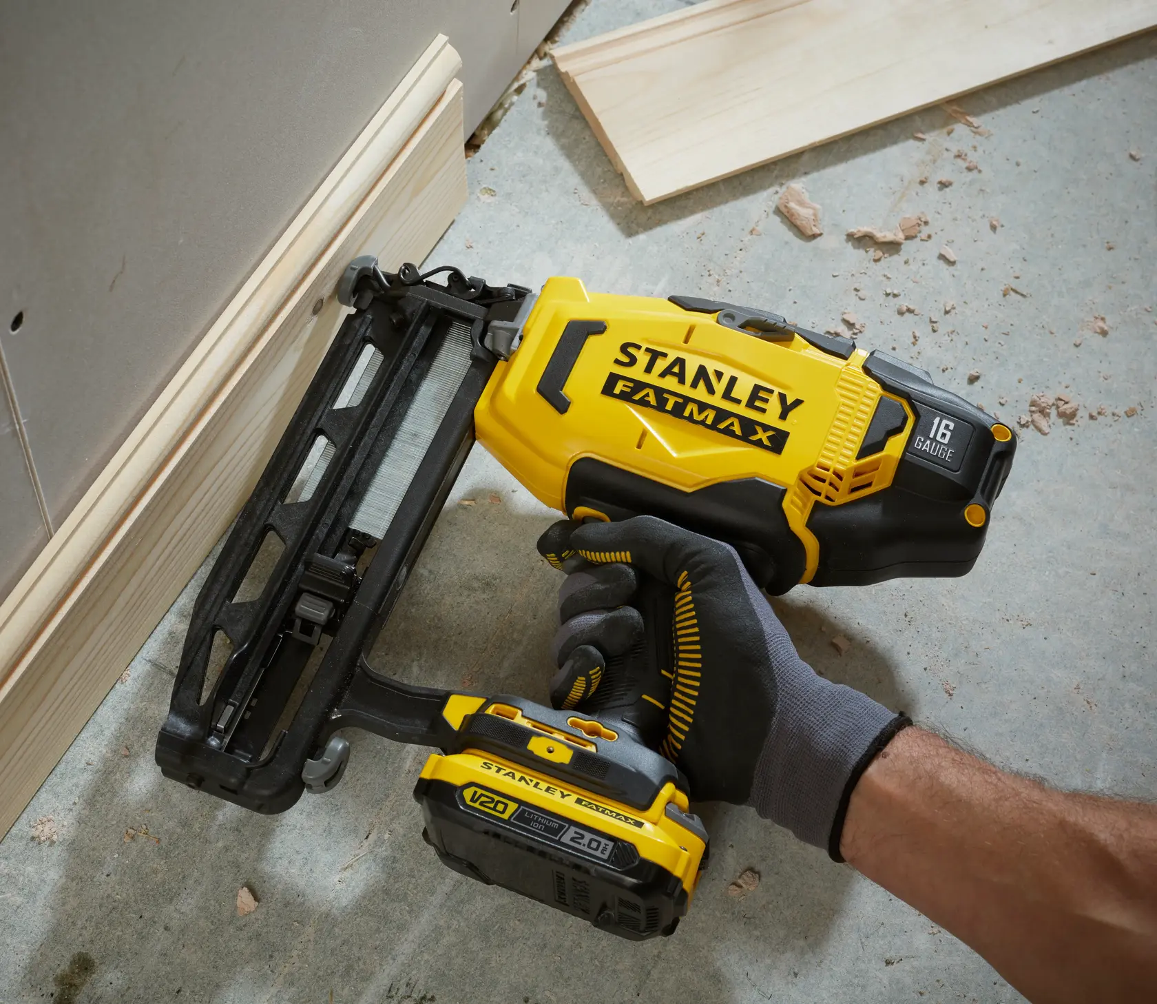 Stanley SCN616 clavadora inalámbrica usada en moldura de madera, ángulo cercano.