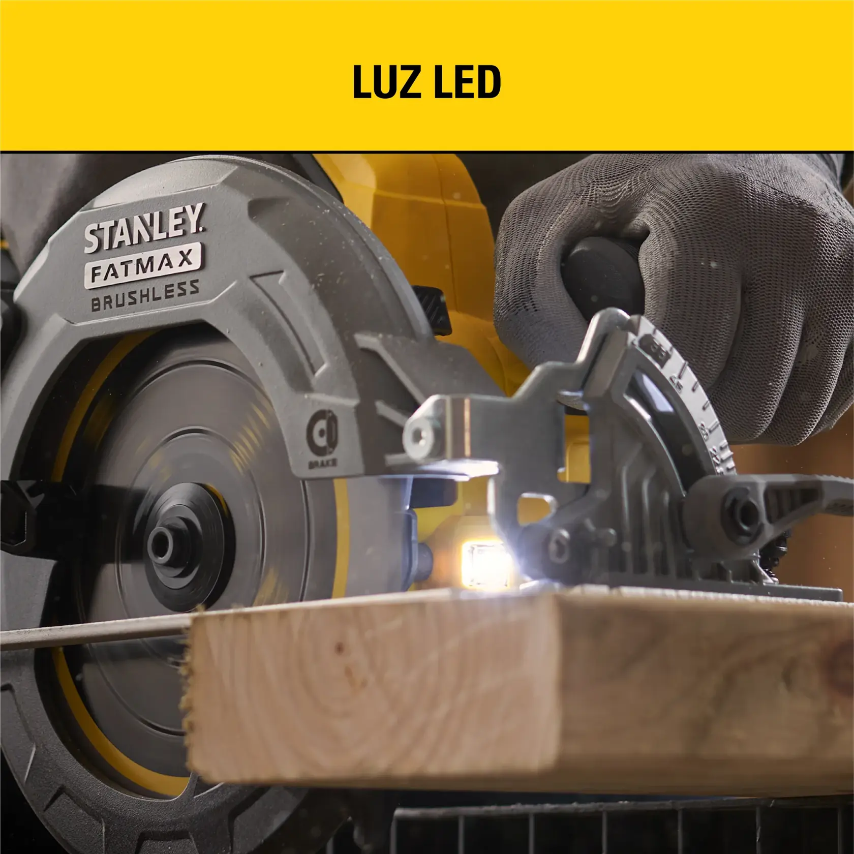 Primer plano de una sierra circular STANLEY FATMAX sin escobillas cortando una tabla de madera, con luz LED visible durante el funcionamiento. Una mano enguantada sostiene la sierra.