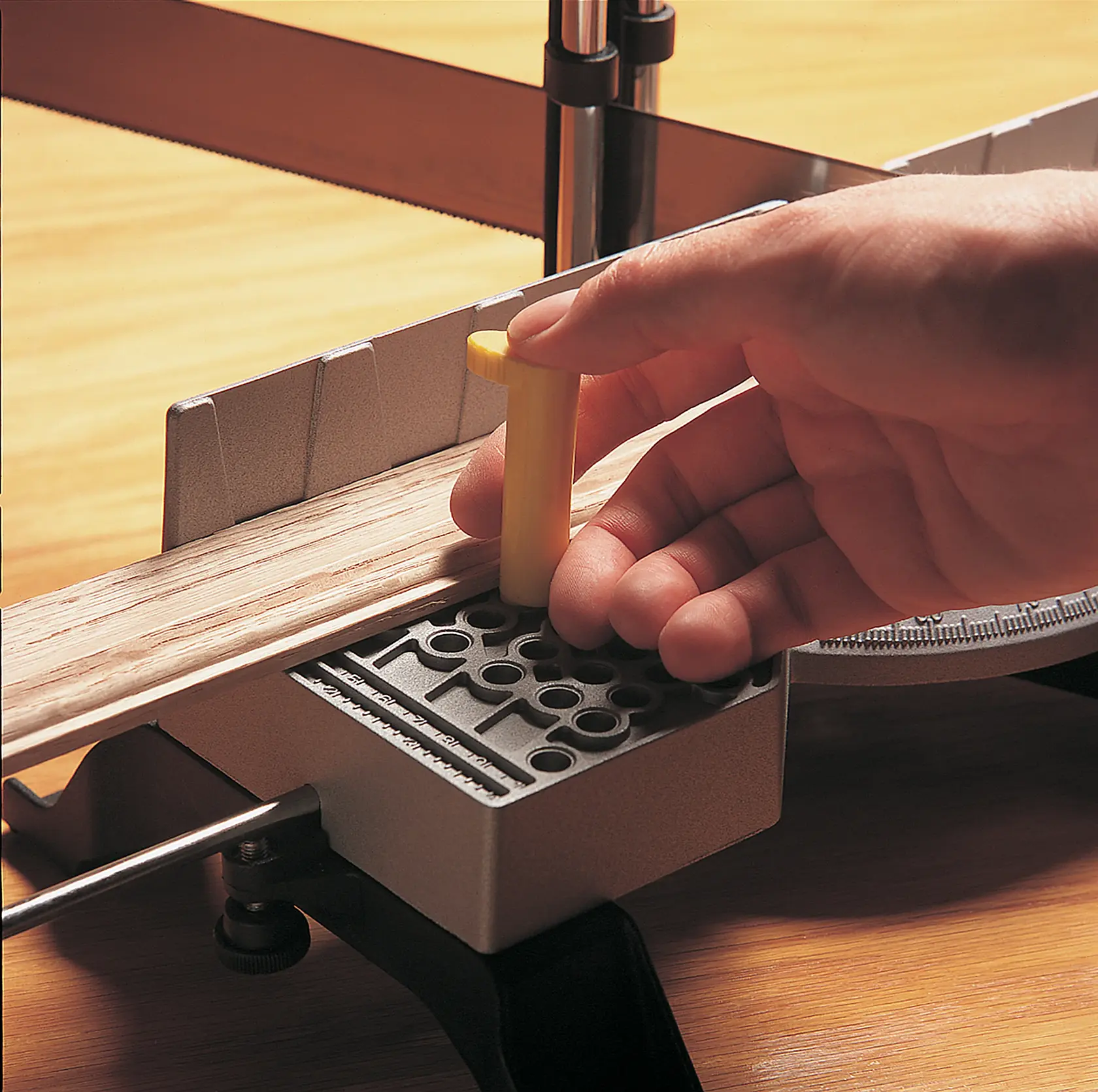 STANLEY 20-800 caja de ingletes fotografía, primer plano de mano colocando pasador amarillo para corte de madera.