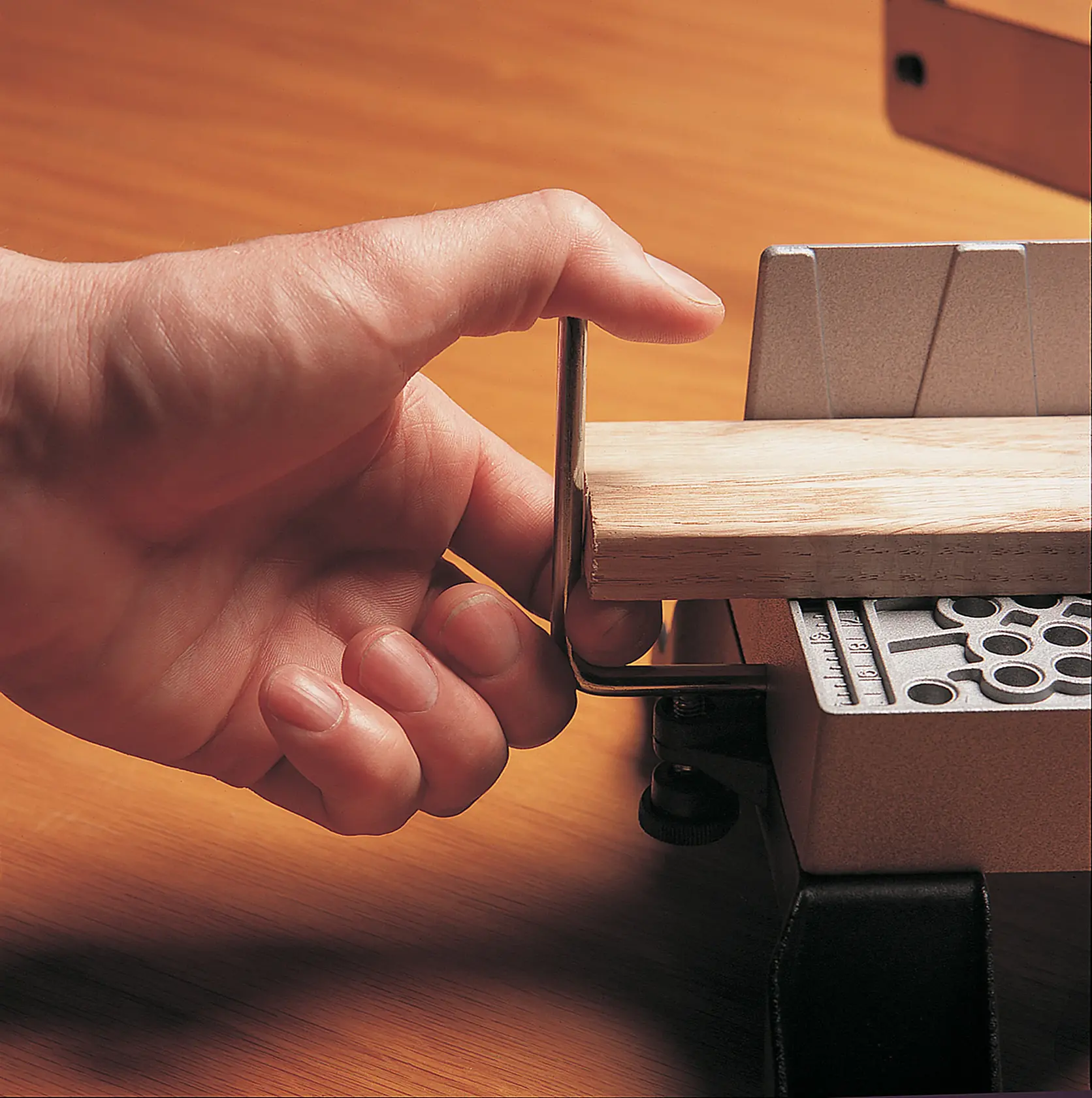 STANLEY 20-800 fotografía de una mano usando una caja de ingletes para sujetar una pieza de madera, vista de cerca.