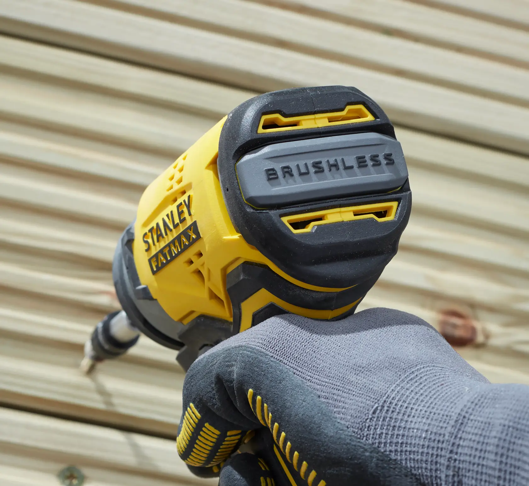 Stanley SBI810D2K-B3 destornillador de impacto amarillo y negro, primer plano en uso, mano enguantada, FATMAX