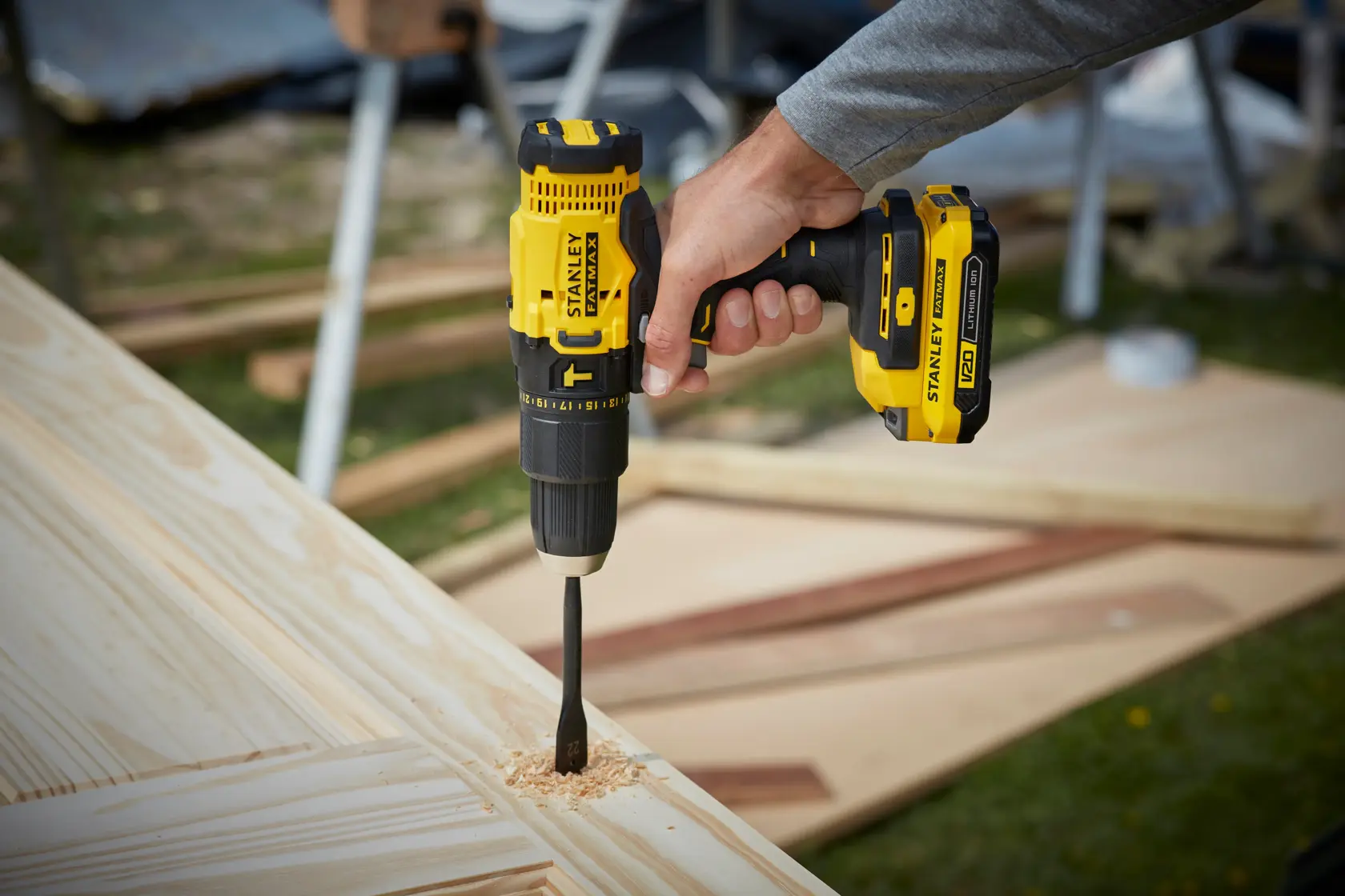 Taladro inalámbrico STANLEY SCD711C2K-BR siendo utilizado para perforar madera, primer plano de la herramienta en acción.