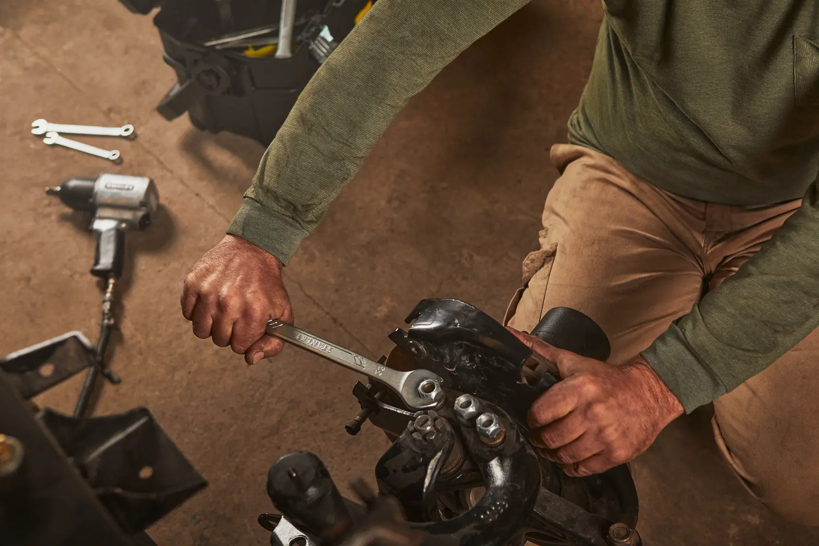 Fotografía de la llave STANLEY STMT72819 en uso sobre maquinaria, con herramientas y caja de herramientas cerca, categoría: fotografía.