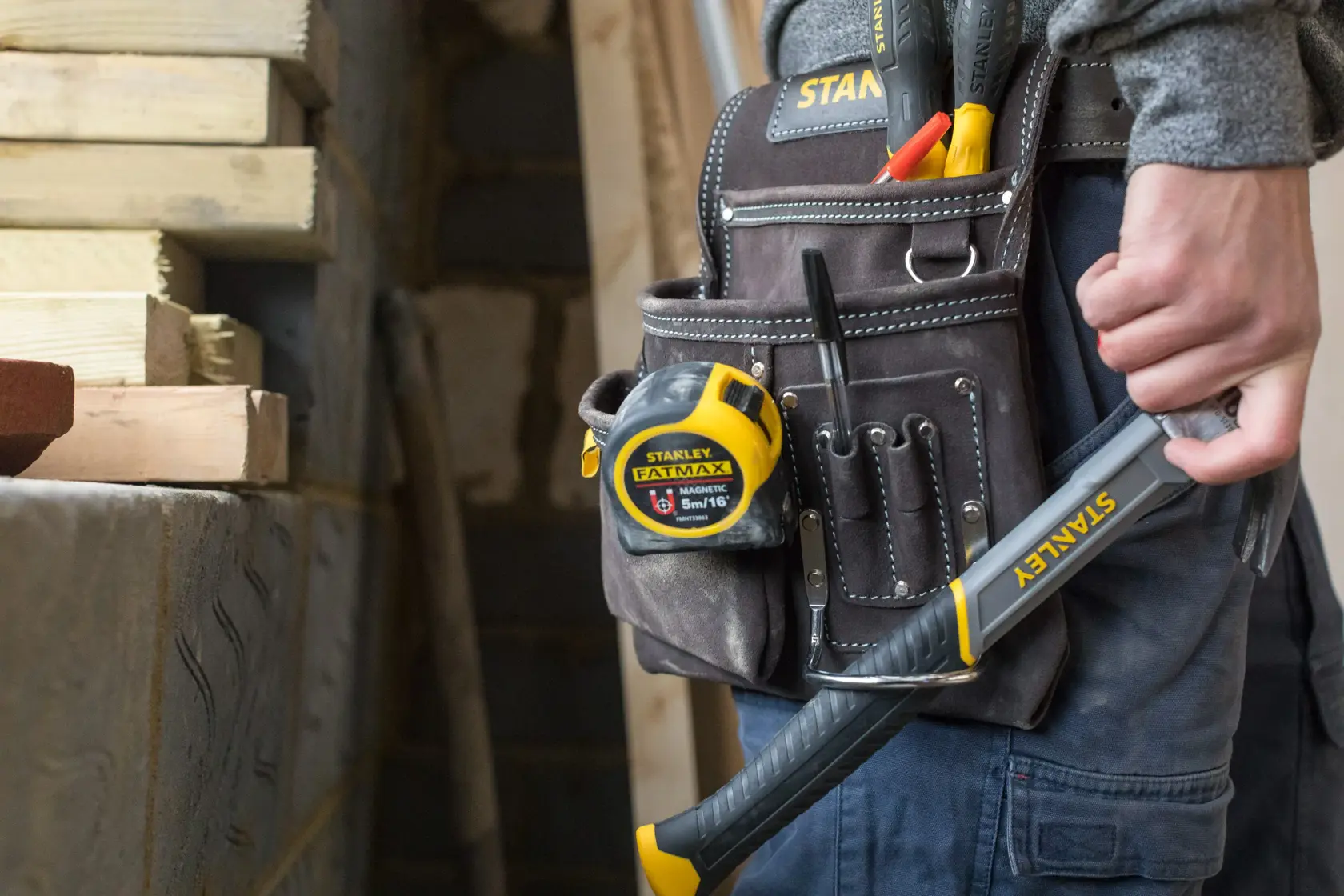 STANLEY STST1-80114 cinturão de ferramentas com trena, ferramentas e martelo em uso na construção.