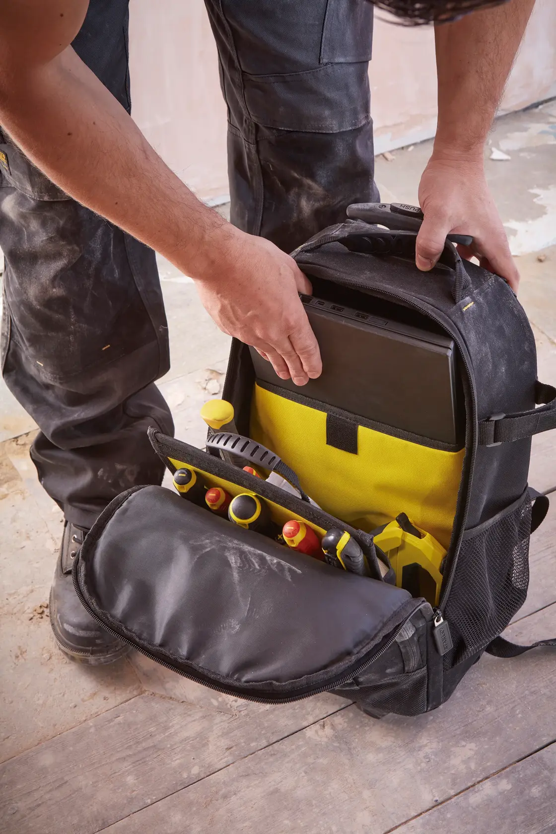 STANLEY STST83307-1 mochila de ferramentas com interior amarelo, bolso aberto mostra ferramentas e tablet.